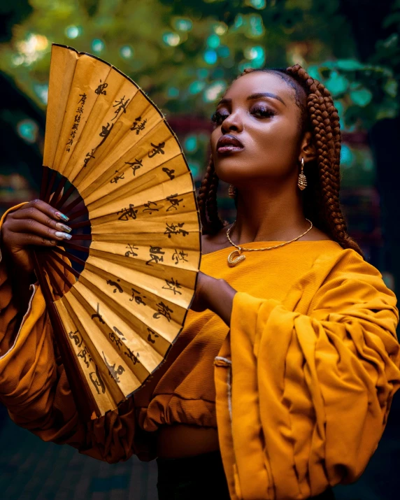 a woman in an orange top holding a hand fan