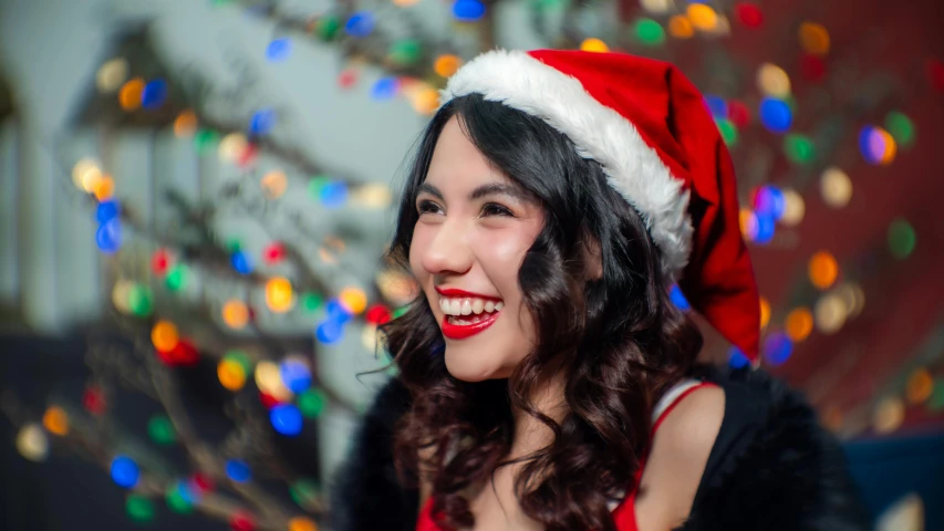 a woman wearing a santa claus hat looks at the camera