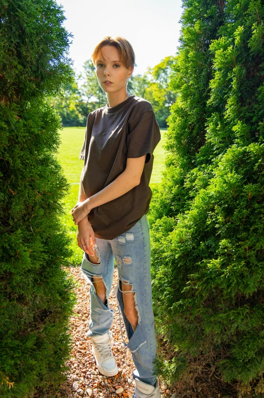 a young woman stands in between two trees