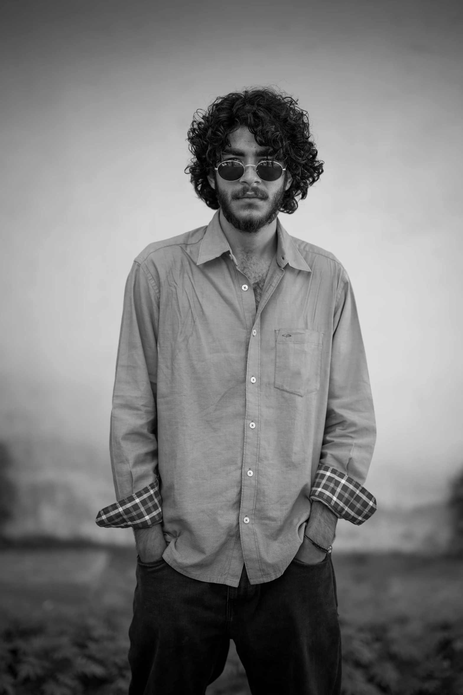 a man in glasses and a shirt is posing for the camera