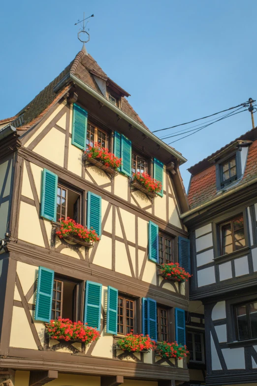 a building with flowers on each window and a street light in front