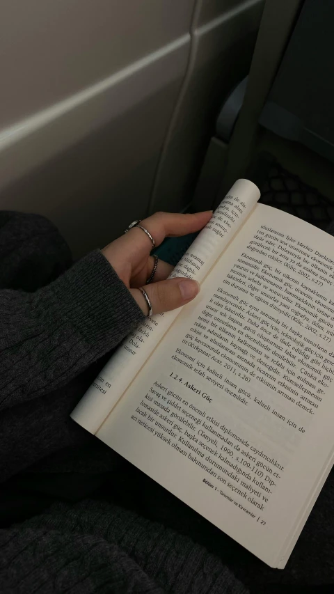 a woman's hand holds open a book