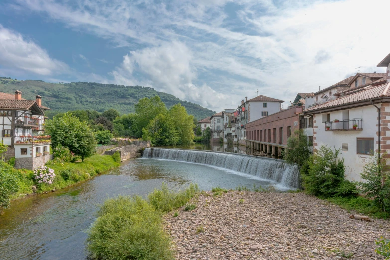 buildings sit in the background and a creek in the foreground