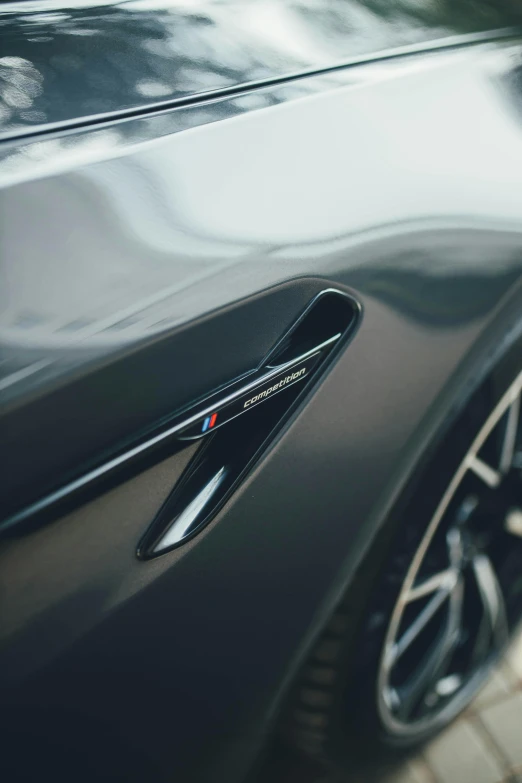 the back end of a black car with chrome trim