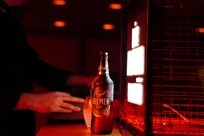 a glass bottle of beer sitting next to a toaster oven