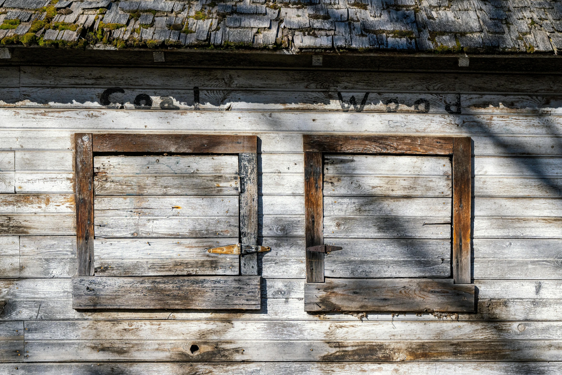 a building has two wooden doors with a green roof