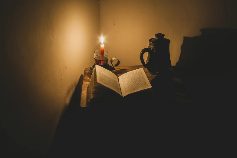 a book is opened on a table next to a tea kettle