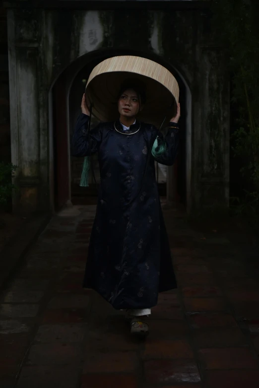 a woman with a hat walking through a tunnel