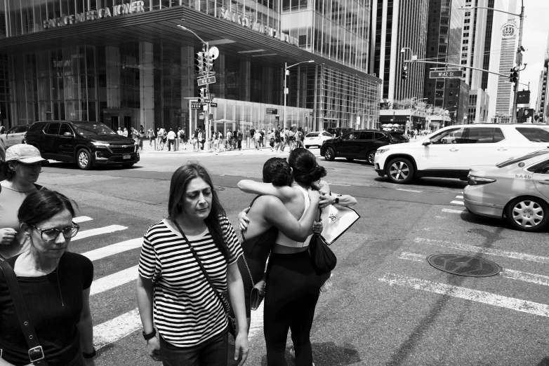 a couple of women standing on the side of a road