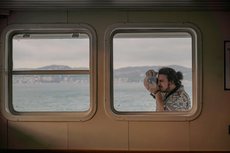 a woman in patterned shirt talking on cellphone through a window