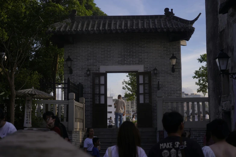 a person walks toward a building as people look on