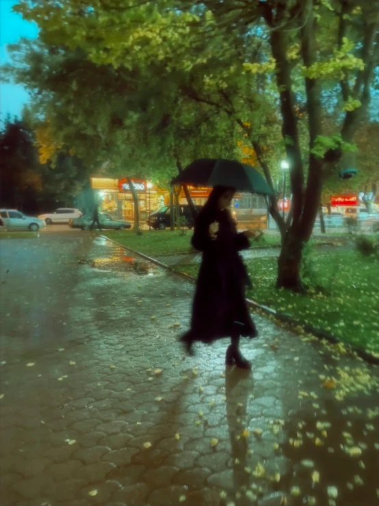 a woman walks down the street with an umbrella in the rain