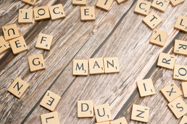 scrabbled letters spelling multiple words on a wooden background