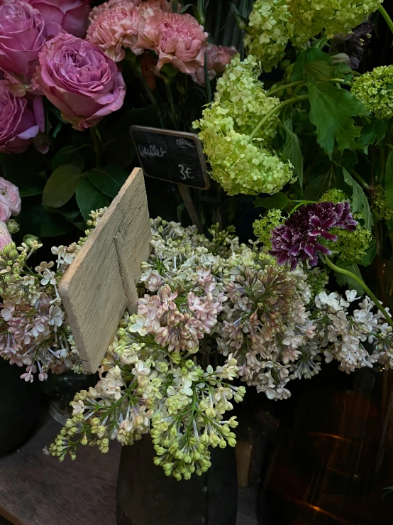 a collection of flowers in old vases with tags on them