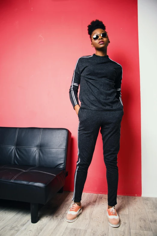 a young man standing next to a couch with an arm in the air