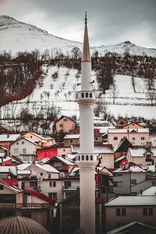 a snowy city in winter with white buildings and a clock tower