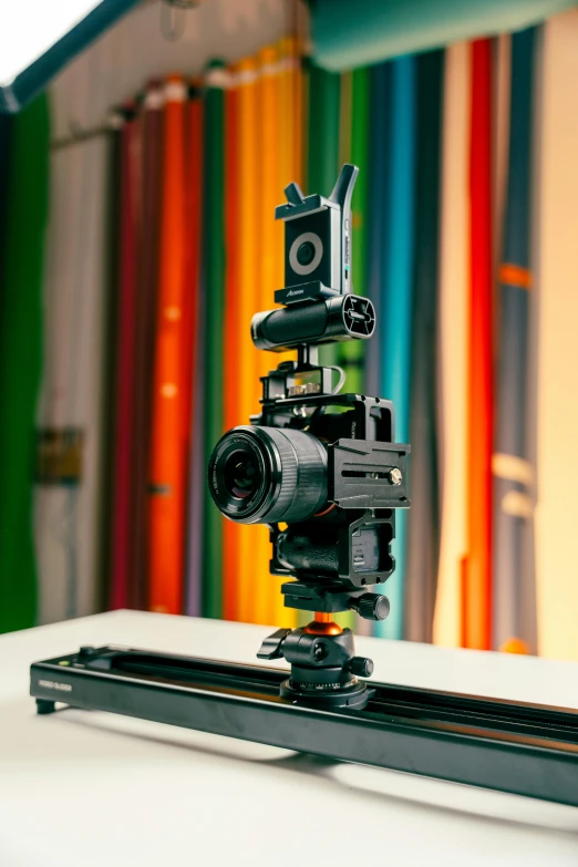 a black camera mounted to top of a wooden tripod
