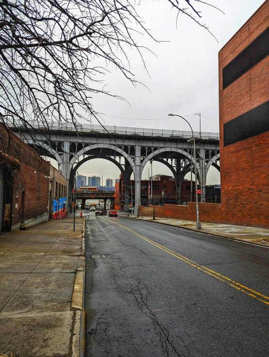 the empty street is leading into an empty brick building