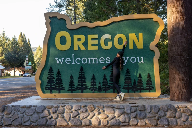 a man standing next to a large welcome sign