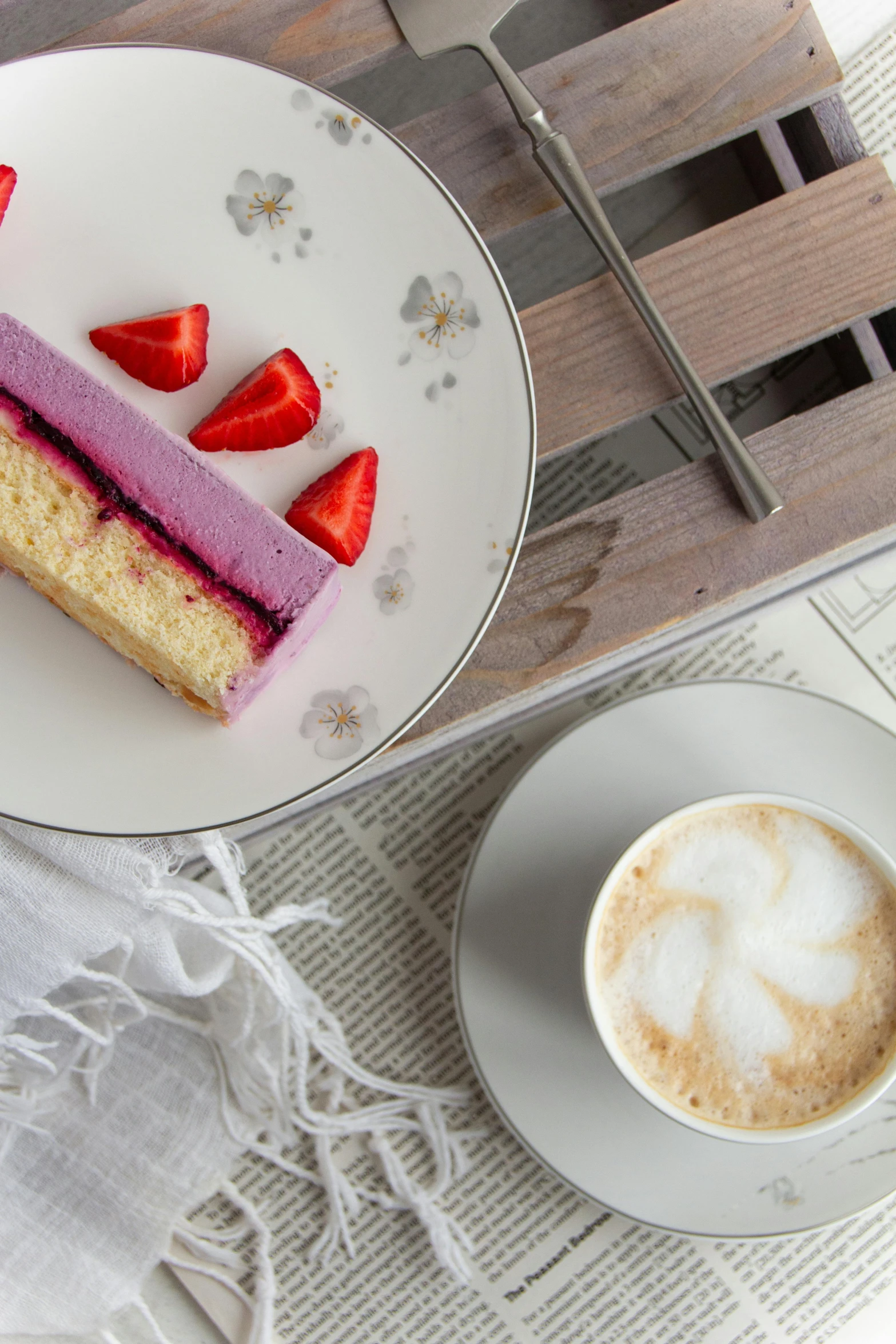 a piece of cake on a plate with strawberries next to it