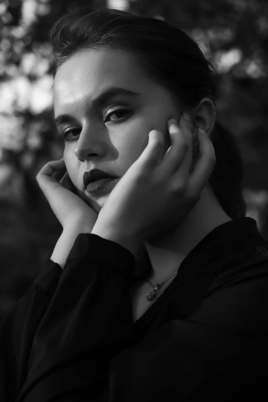 black and white pograph of a woman posing with her hands on her head