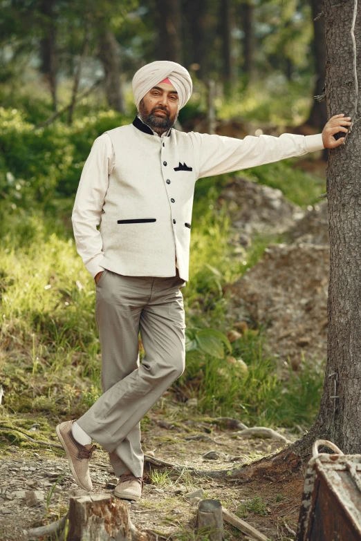 an indian man wearing a turban poses in the woods