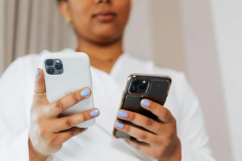 there is a woman holding two cell phones in her hands