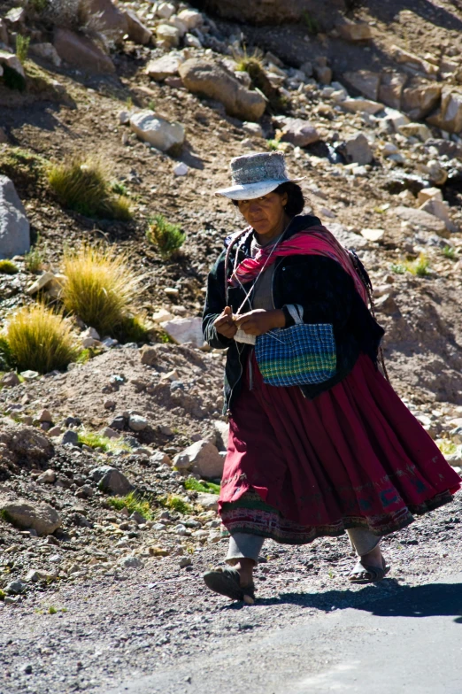 a woman walking down a mountain road