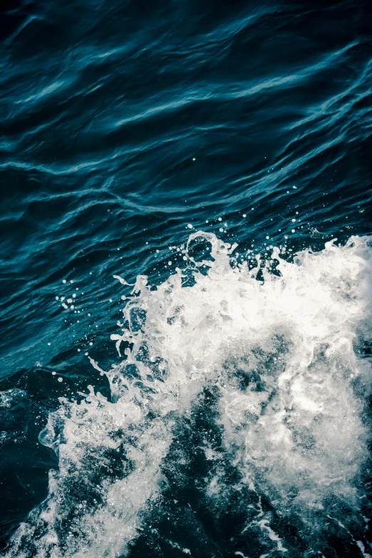 water surface covered with white waves with small drops