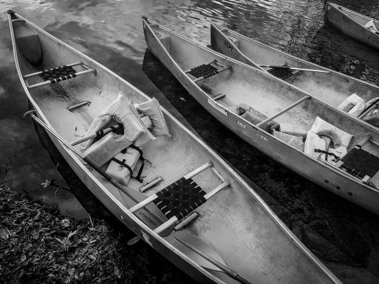 two boats sitting in the water next to each other