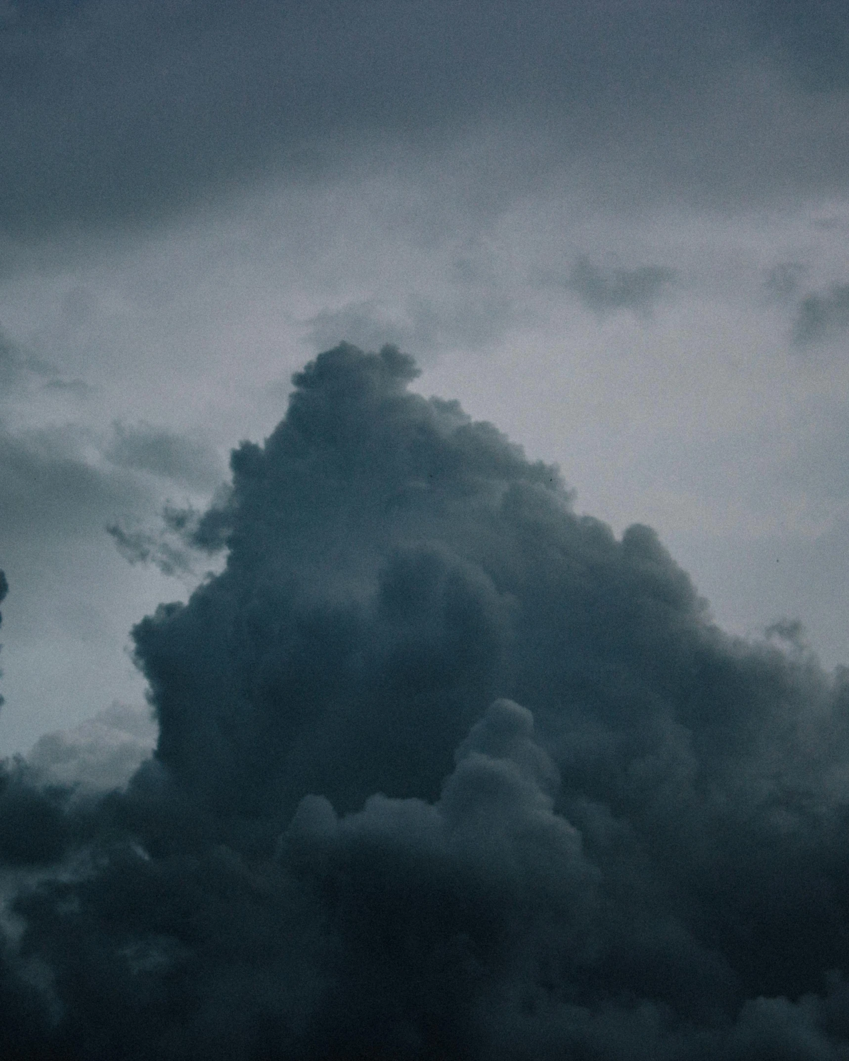 there is a black cloud in the sky above a airplane