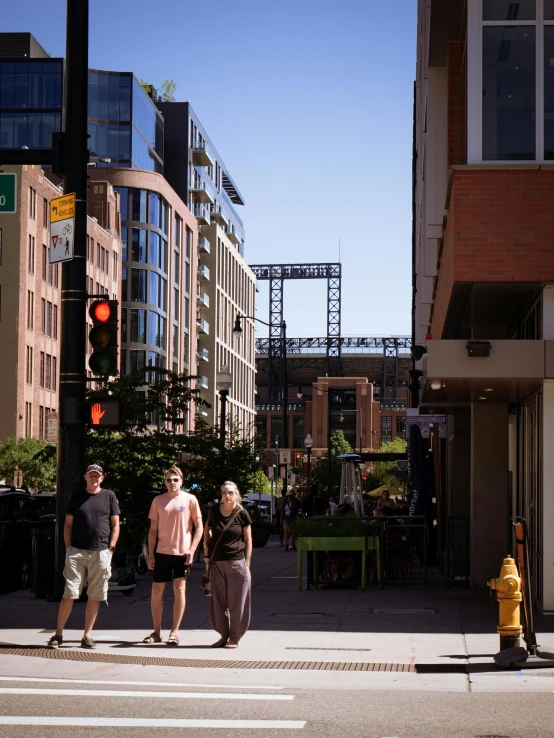 three people are standing near a yellow fire hydrant