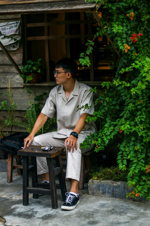 a man sits on a small table and poses for the camera