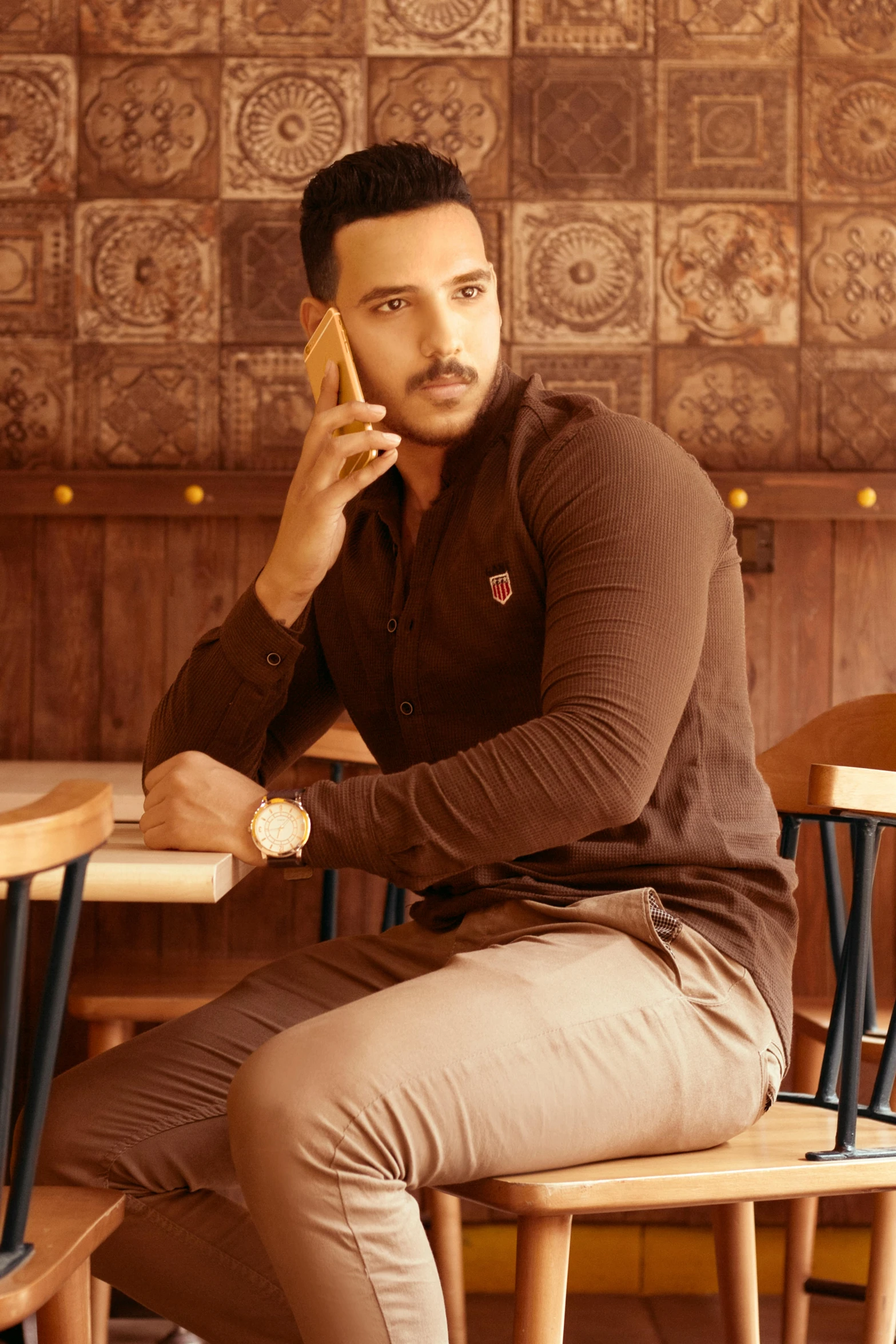 man sitting at a table holding a wood stick