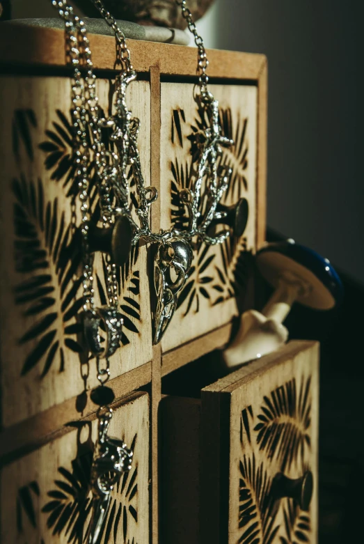 wooden boxes hold a silver and crystal chain necklace