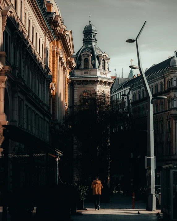 man walking on walkway in city setting near buildings