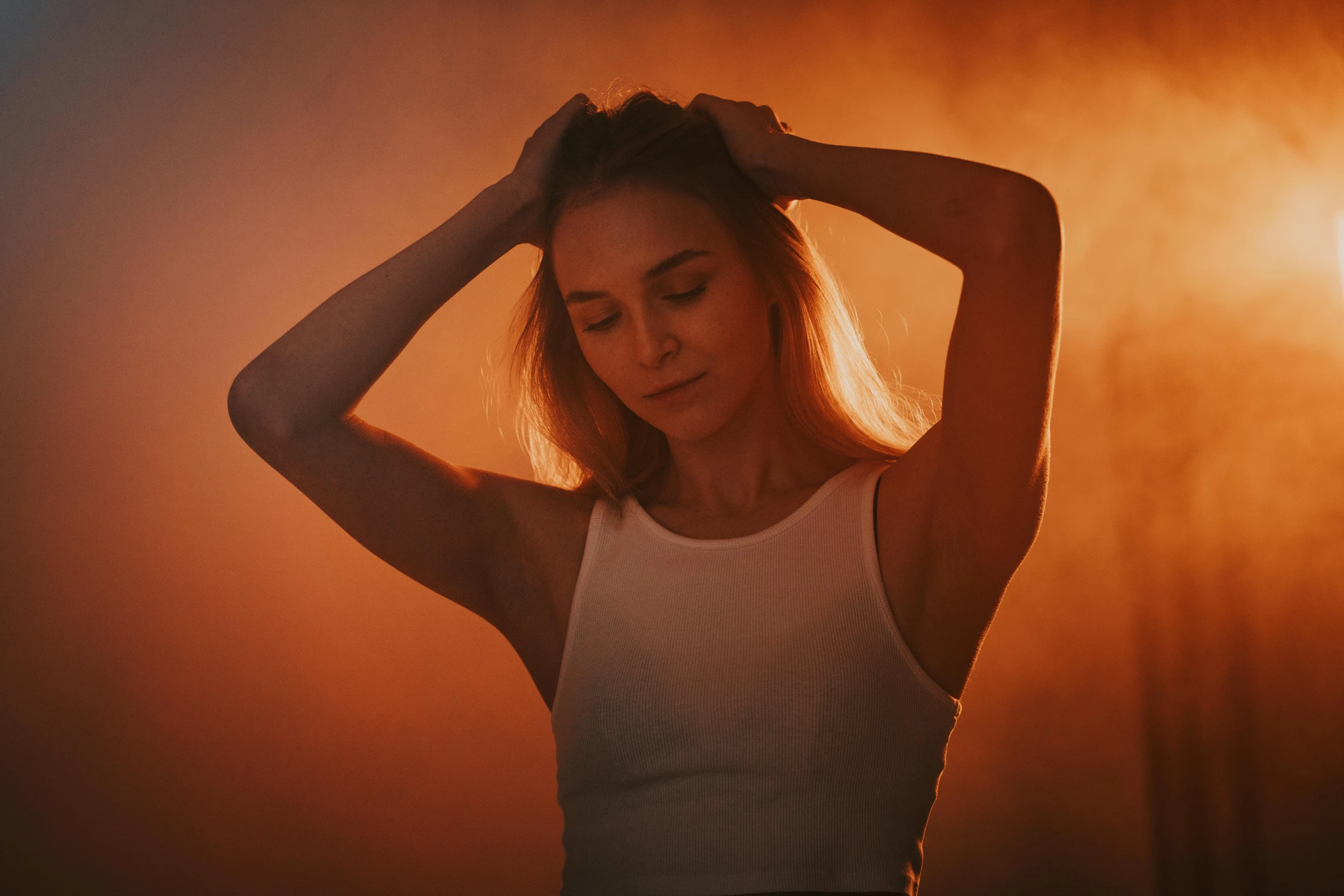 a woman is holding her hair back