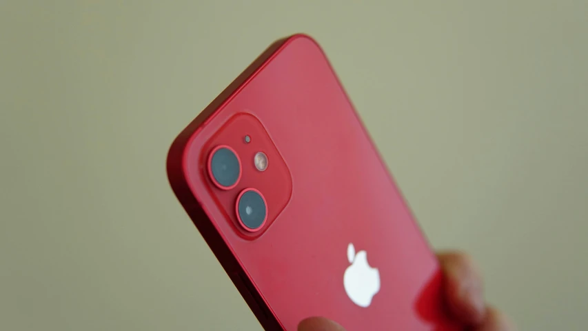 a red iphone in front of someone holding it