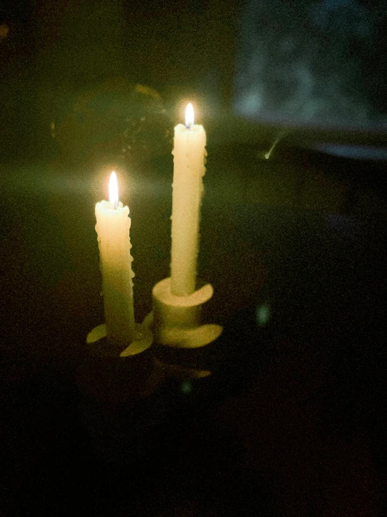three candles in dark room with dim lighting