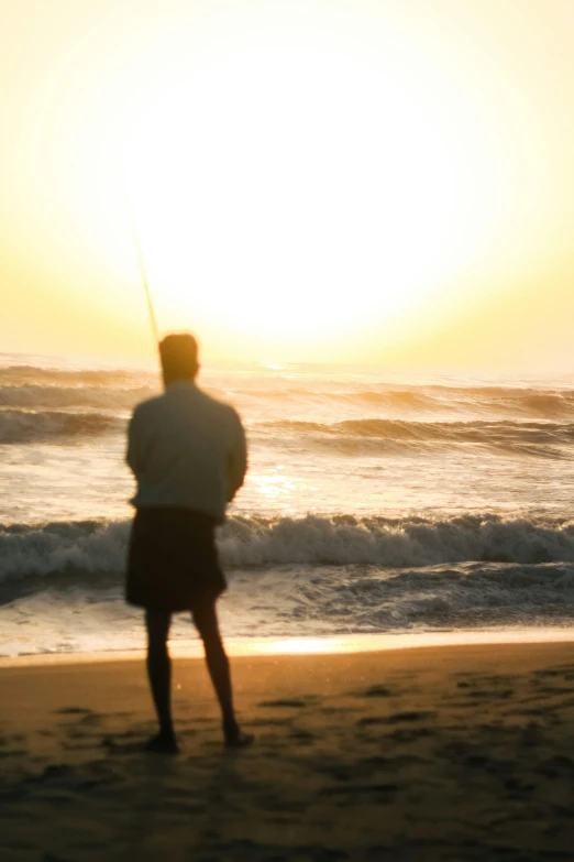 a man on the beach watching the sunset