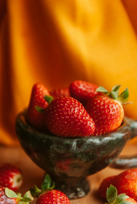 there is a bowl full of strawberries on the table