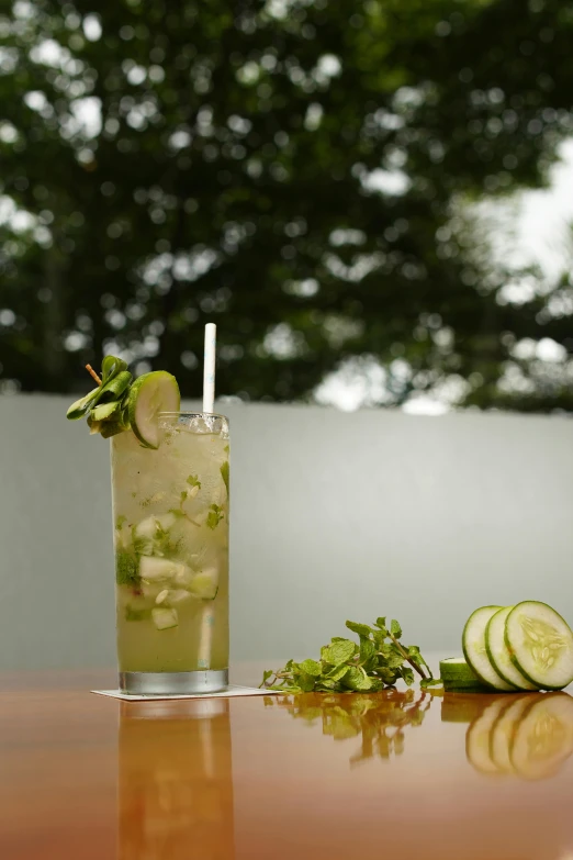 cucumber juice in a glass with green garnish and a straw