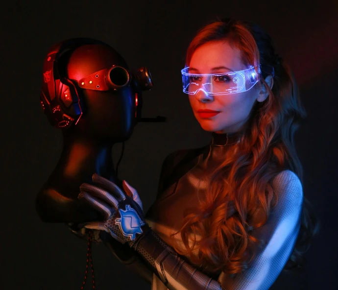 a woman wearing glasses holding a glowing helmet