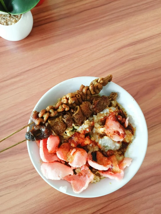 a white plate topped with meat, rice and veggies