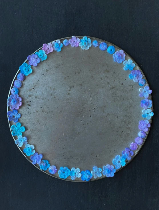 a blue, purple and orange flowered plate that has been decorated