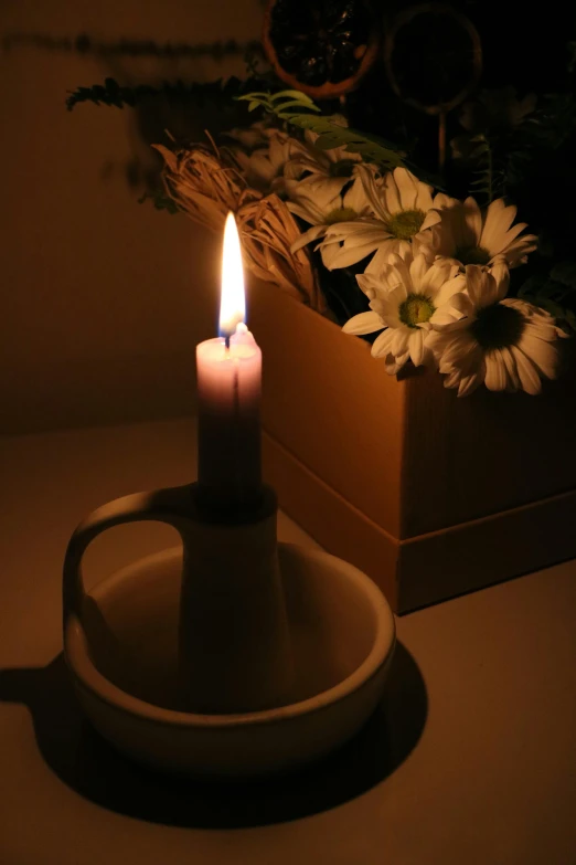 a candle is placed in front of a flower box