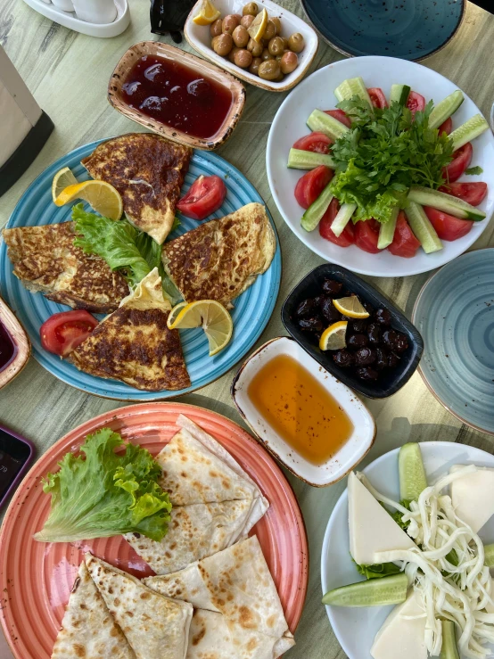 a table with plates and plates of food and various sauces