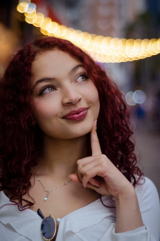 a woman with red hair and a necklace on her chest