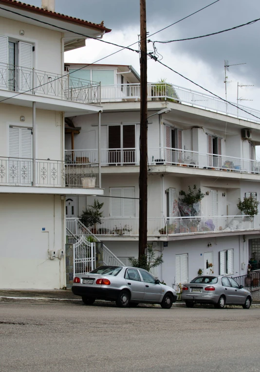 two cars are parked in front of apartment buildings