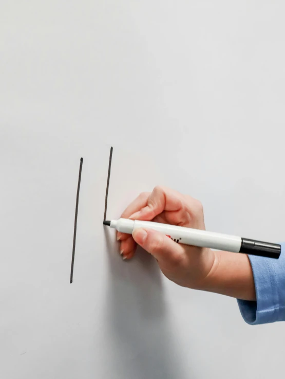 a hand holding a pencil and a drawing soing